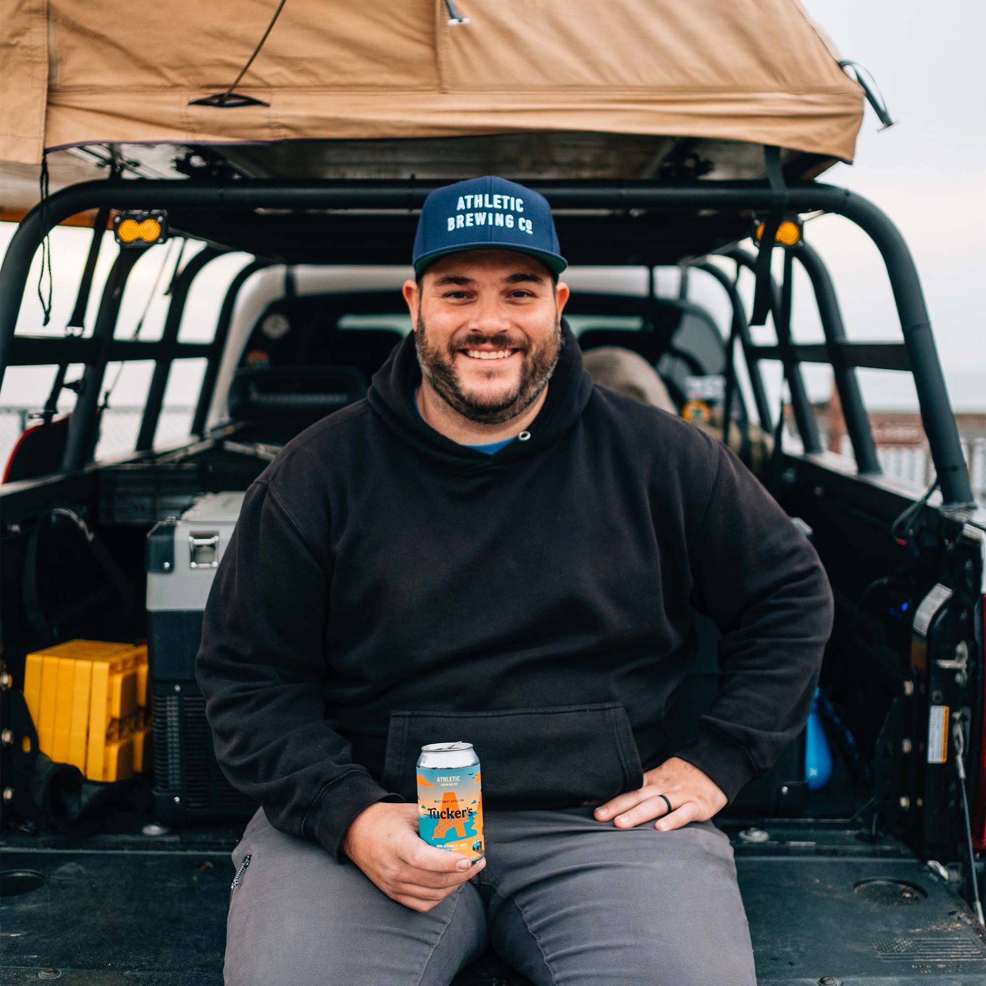 person in back for truck holding a tuckers can